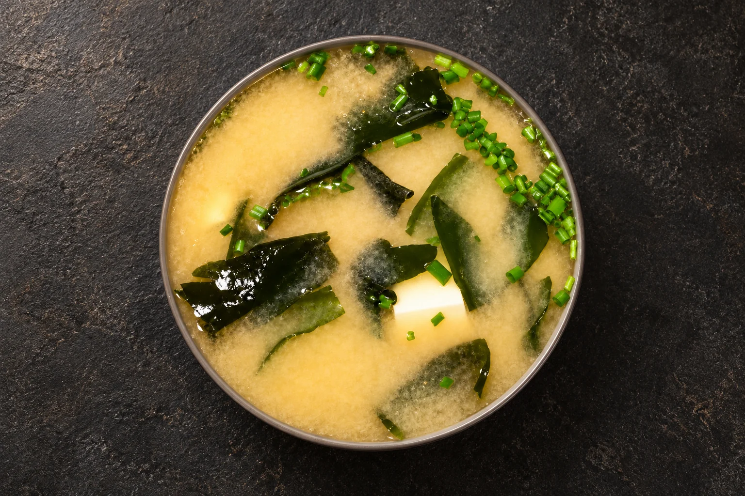 Miso soup in a bowl against a dark background